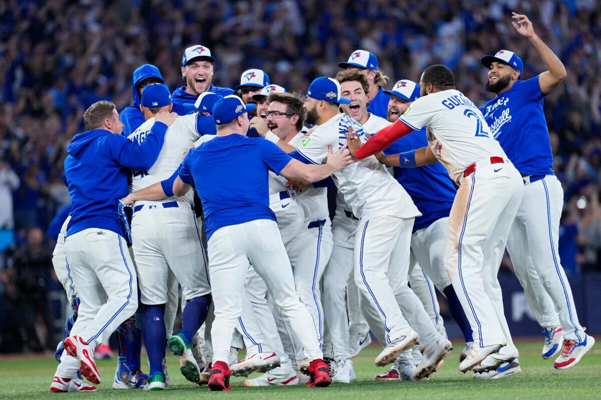 Toronto Blue Jays players celebrate on the field after defeating the Seattle Mariners in Game 7 of the American League Championship Series at the Rogers Centre in Toronto on Oct. 20, 2025. (Mark Blinch/Getty Images)