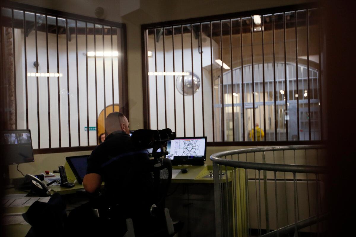 A prison service guard checks the security screens at the entrance of La Sante prison during a press visit after a four-year renovation project, in Paris on April 12, 2019. (AP Photo/Francois Mori, File)