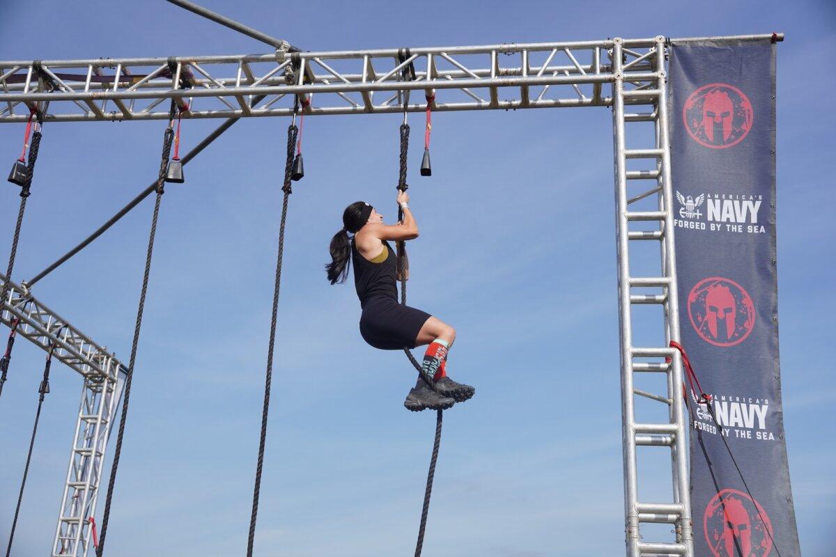 Runner does a rope climb at the 2025 Tri-State New York Spartan Event Weekend in the Town of New Hampton, N.Y., on Oct. 19, 2025. (Oliver Mantyk/The Epoch Times)