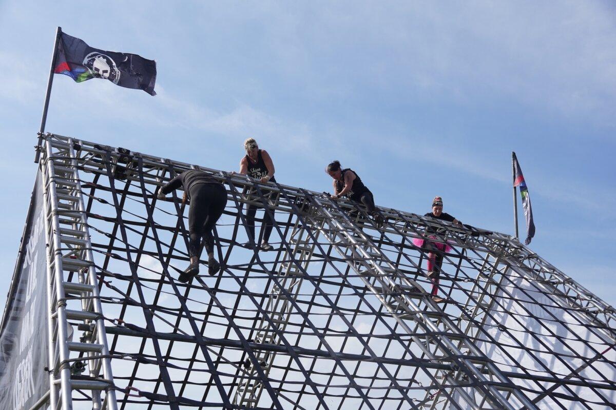 Runners climb an obstacle at the 2025 Tri-State New York Spartan Event Weekend in the Town of New Hampton, N.Y., on Oct. 19, 2025. (Oliver Mantyk/The Epoch Times)