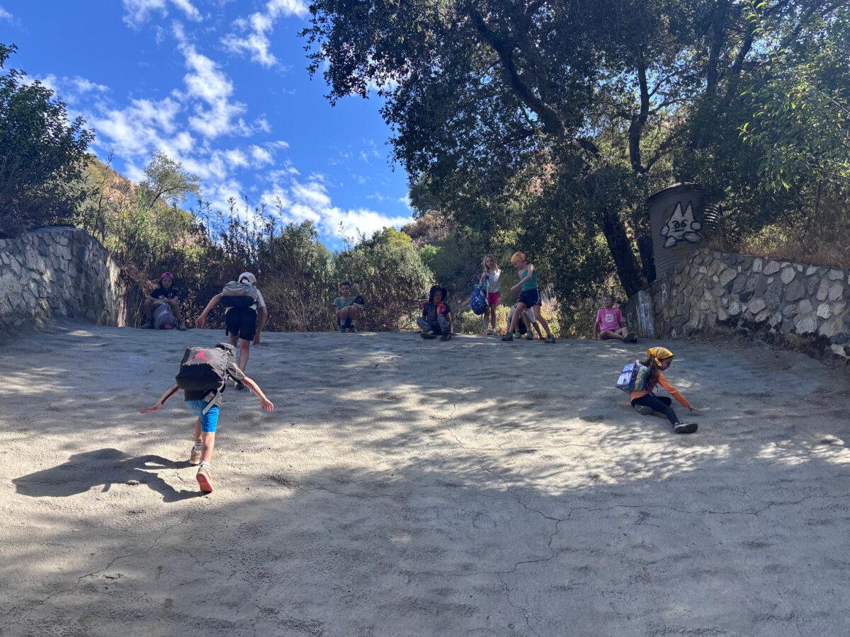 Children from a HAWKs group slide down a concrete channel just off the Gabrielino Trail near Pasadena, Calif. (Jaclyn Cosgrove/Los Angeles Times/TNS)