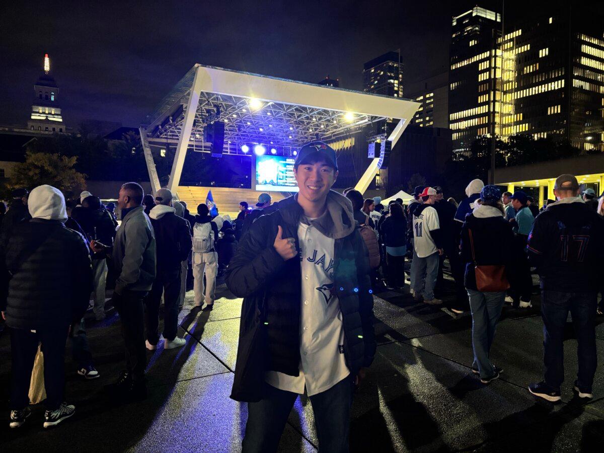 Kazuo Nambara watches the Toronto Blue Jays' first game in the World Series against the LA Dodgers at a viewing party at Nathan Phillips Square in Toronto on Oct. 24, 2025. (Olivia Gomm/The Epoch Times)