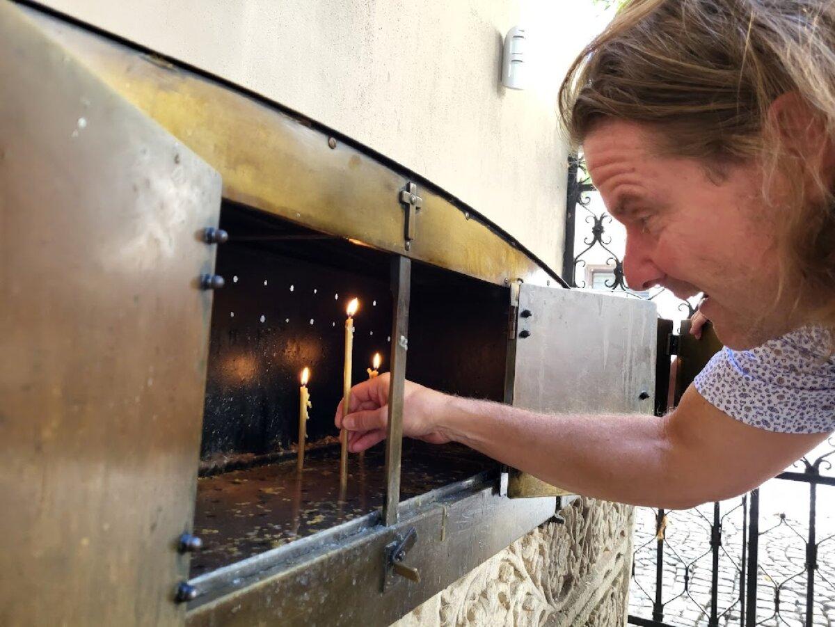 A visitor lights a candle in a lumanarar—a traditional Romanian shrine for prayers to the living and the dead—outside Stavropoleos Monastery in Bucharest's Old Town. (Photo courtesy of Carmen Zermeno)