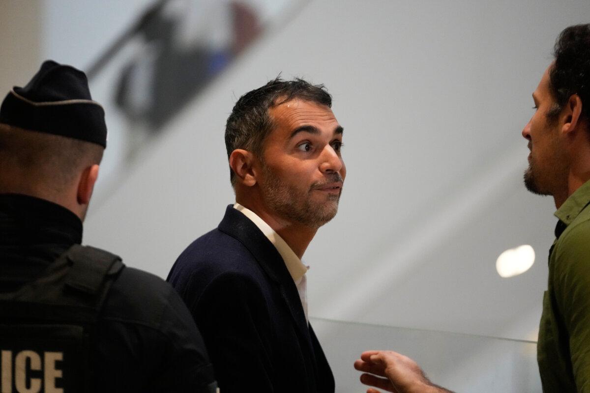 Defendant Aurelien Poirson-Atlan, center, arrives at the courtroom as 10 people were put on trial over cyberbullying of Brigitte Macron after spreading claims that President Emmanuel Macron’s wife was a man, in Paris on Oct. 27, 2025. (Michel Euler/AP Photo)