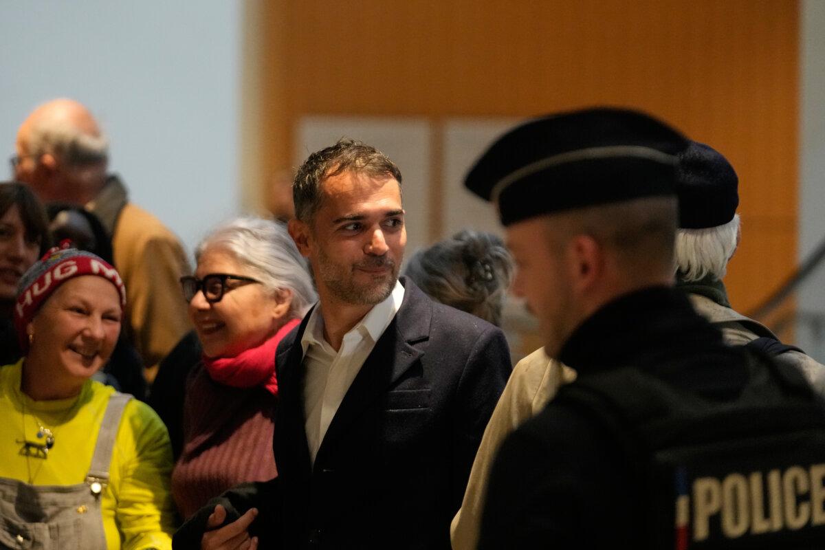Defendant Aurelien Poirson-Atlan (C) arrives at the courtroom in Paris on Oct. 27, 2025. (AP Photo/Michel Euler)