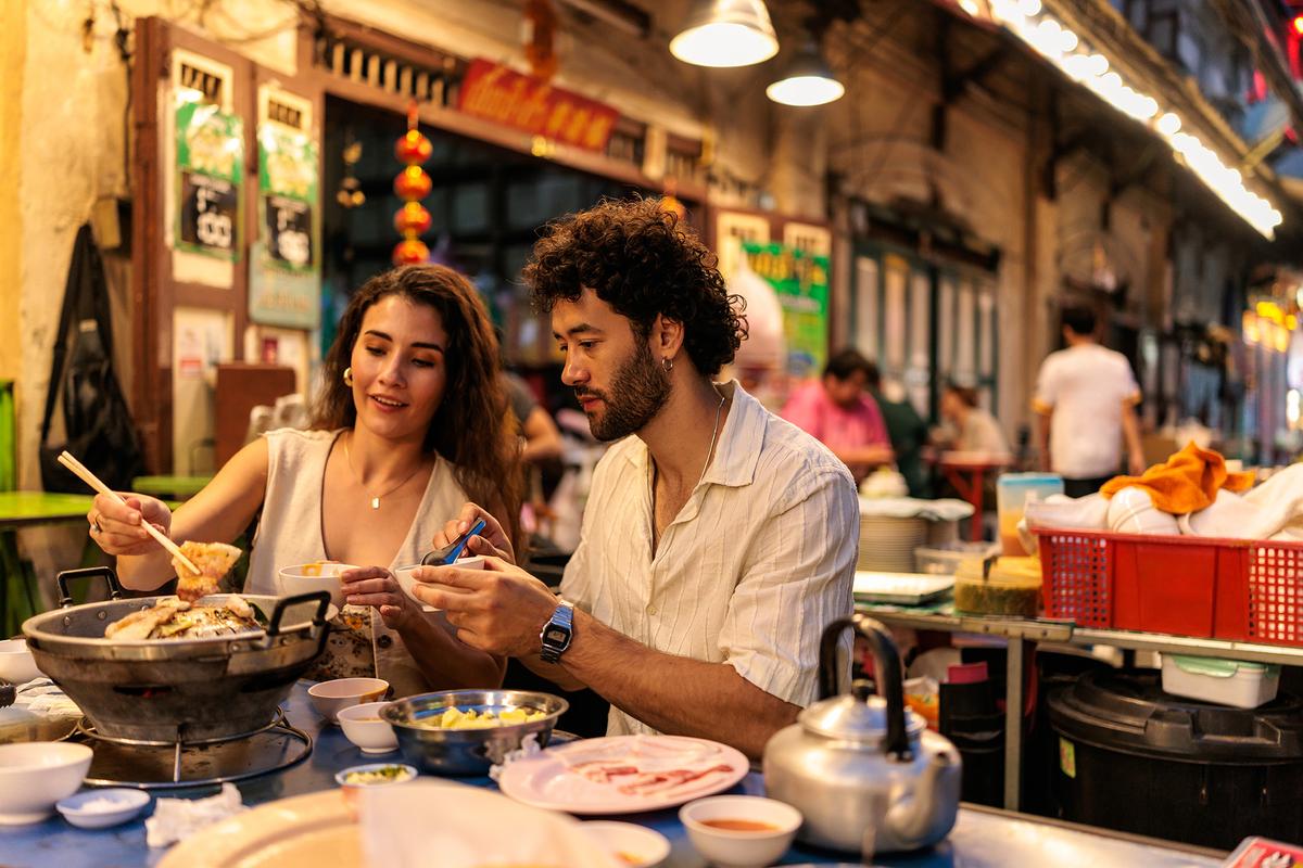 Hot pots are a popular communal dining option in Thailand. They typically involve thinly sliced meats, seafood, and vegetables cooked in a big pot of simmering broth. (miodrag ignjatovic/Getty Images)