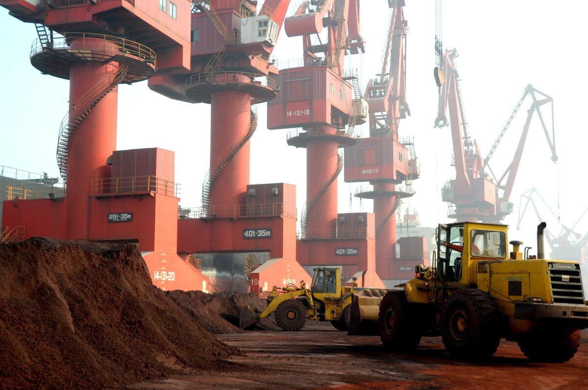Trabajadores transportan tierra que contiene elementos de tierras raras para su exportación en un puerto de Lianyungang, provincia de Jiangsu, China, el 31 de octubre de 2010. (Reuters/Stringer)