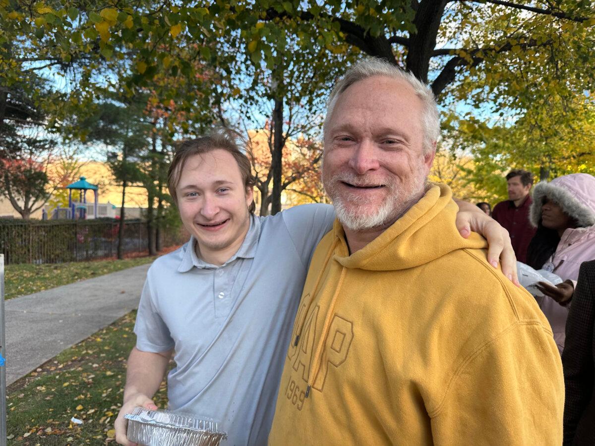 John Freeze and his son Orion attend Mikie Sherrill's gubernatorial rally in Newark, N.J., on Nov. 1, 2025. (Juliette Fairley/The Epoch Times)