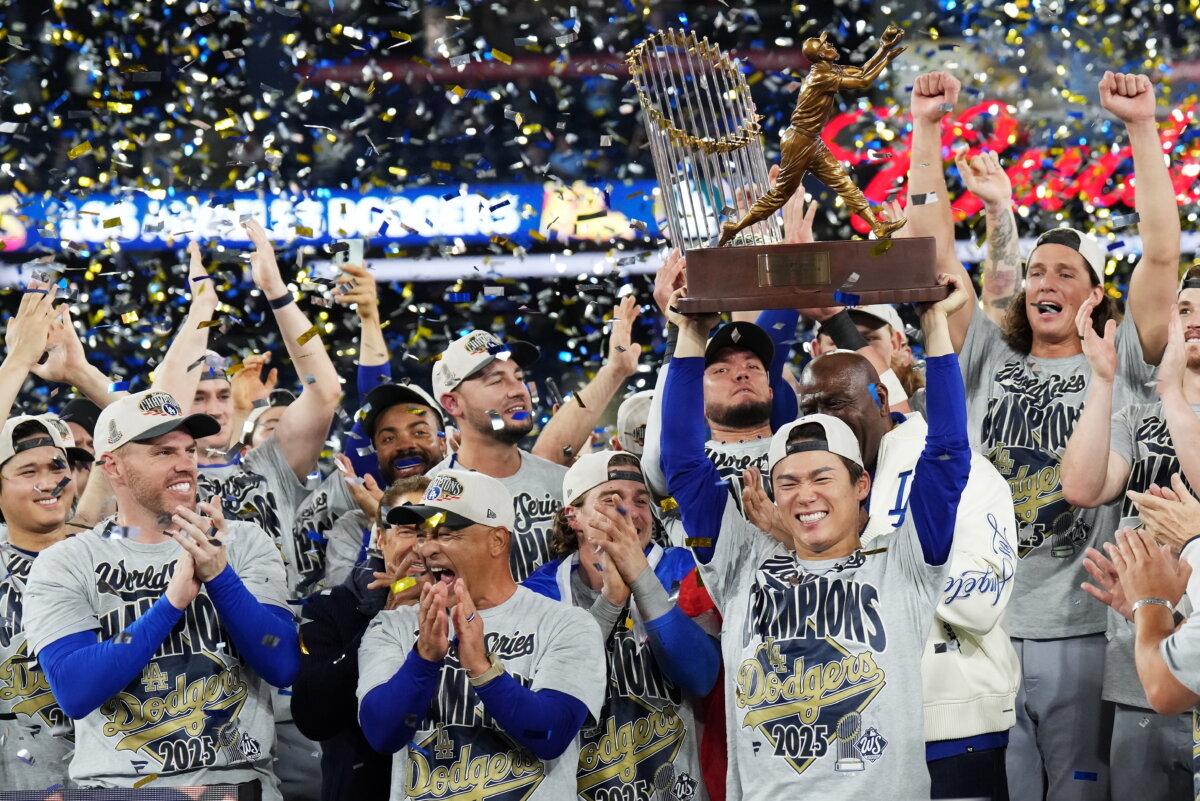 Los Angeles Dodgers pitcher Yoshinobu Yamamoto (center R) lifts the World Series MVP trophy as the Dodgers celebrate after defeating the Toronto Blue Jays in Game 7 of baseball's World Series in Toronto on Nov. 2, 2025. (Nathan Denette/The Canadian Press via AP)