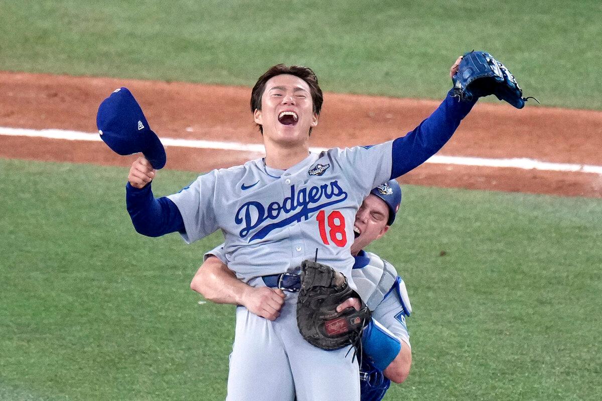 Los Angeles Dodgers' Will Smith celebrates with Yoshinobu Yamamoto (18) after the team defeated the Toronto Blue Jays in Game 7 of baseball's World Series in Toronto on Nov. 2, 2025. (Chris Young/The Canadian Press via AP)