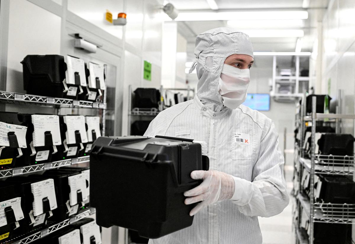 Employee Toni Hrkac holds a box with wafers in a production line of Dutch semiconductor company Nexperia, in Hamburg, Germany, on June 27, 2024. (Fabian Bimmer/Reuters)