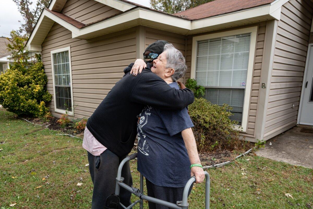 Rodney Smith Jr., founder of Raising Men and Women Lawn Care Service, hugs Frances Helton in Madison, Ala., on Oct. 28, 2025. (Samira Bouaou/The Epoch Times)
