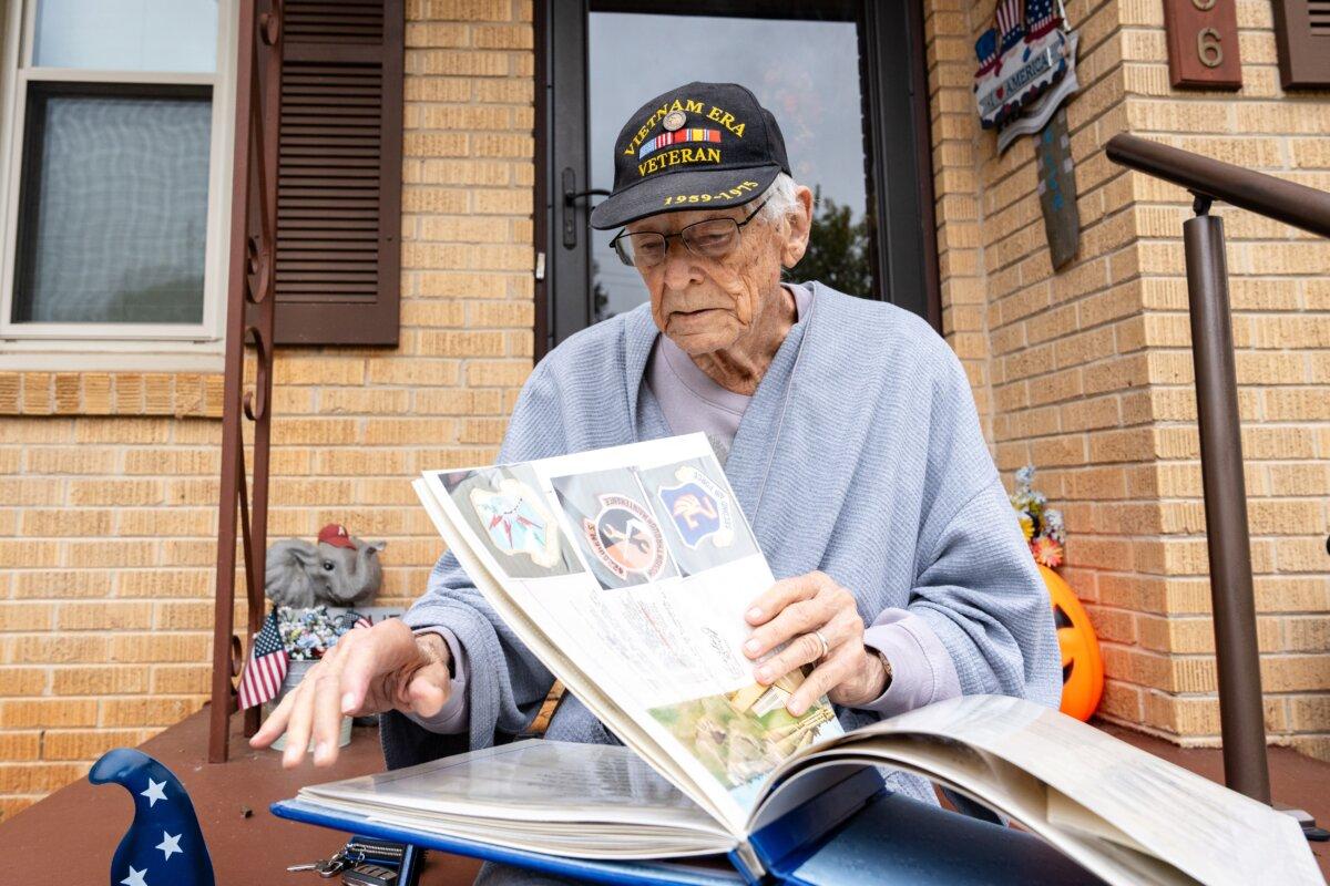 Veteran James Smith, 90, looks through his old photo album in Madison, Ala., on Oct. 28, 2025. (Samira Bouaou/The Epoch Times)