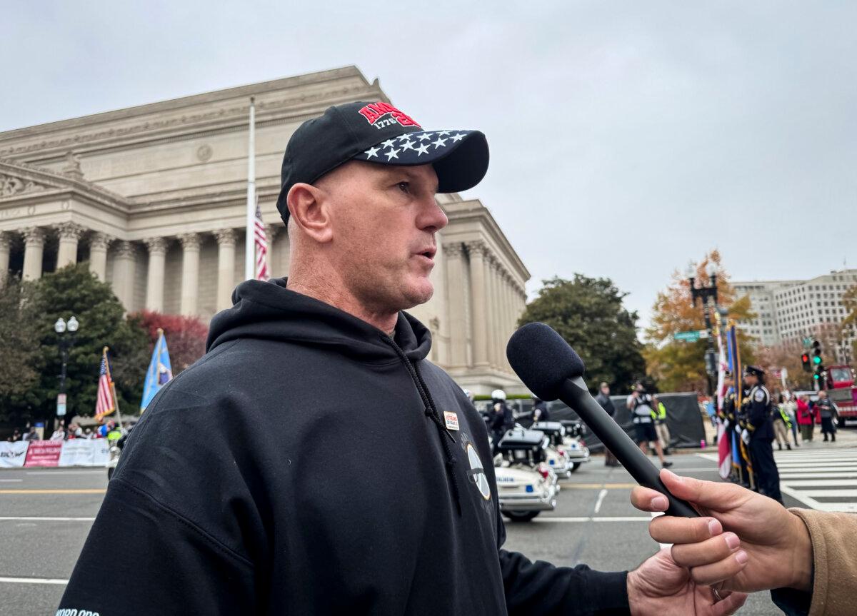 Kyle Copeland, a retired U.S. Army master sergeant, speaks to reporters at the National Veterans Parade in Washington on Nov. 9, 2025. (Emel Akan/The Epoch Times)