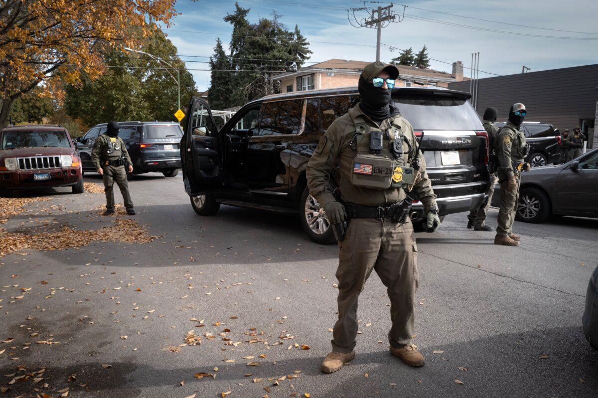 Federal agents stand guard as they are confronted by residents after making a stop while driving in a caravan through the Brighton Park neighborhood of Chicago on Nov. 6, 2025. (Scott Olson/Getty Images)