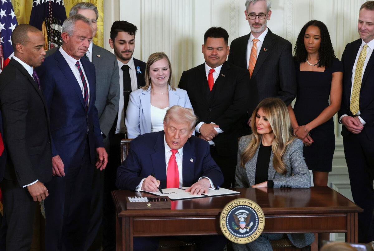 President Donald Trump, joined by First Lady Melania Trump, members of his administration and foster care advocates, signs the "Fostering the Future" executive order in the East Room of the White House in Washington on Nov. 13, 2025. (Anna Moneymaker/Getty Images)
