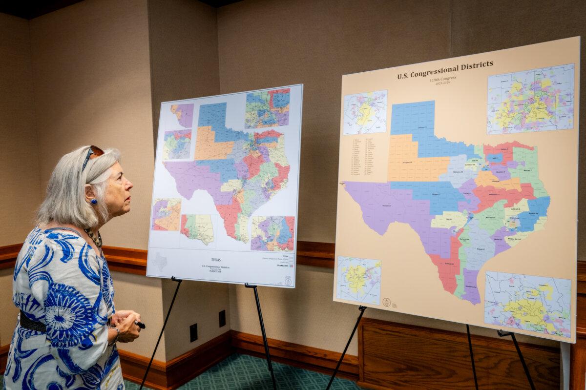A woman looks at Texas congressional district maps as the Senate special committee on redistricting meets to hear testimony at the state Capitol in Austin on Aug. 6, 2025. (Brandon Bell/Getty Images)