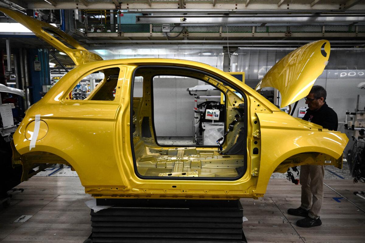 An employee of auto giant Stellantis works on the 500 Hybrid assembly line at the car maker Mirafiori factory in Turin, Italy, on November 25, 2025. (Marco Bertorello/AFP via Getty Images)
