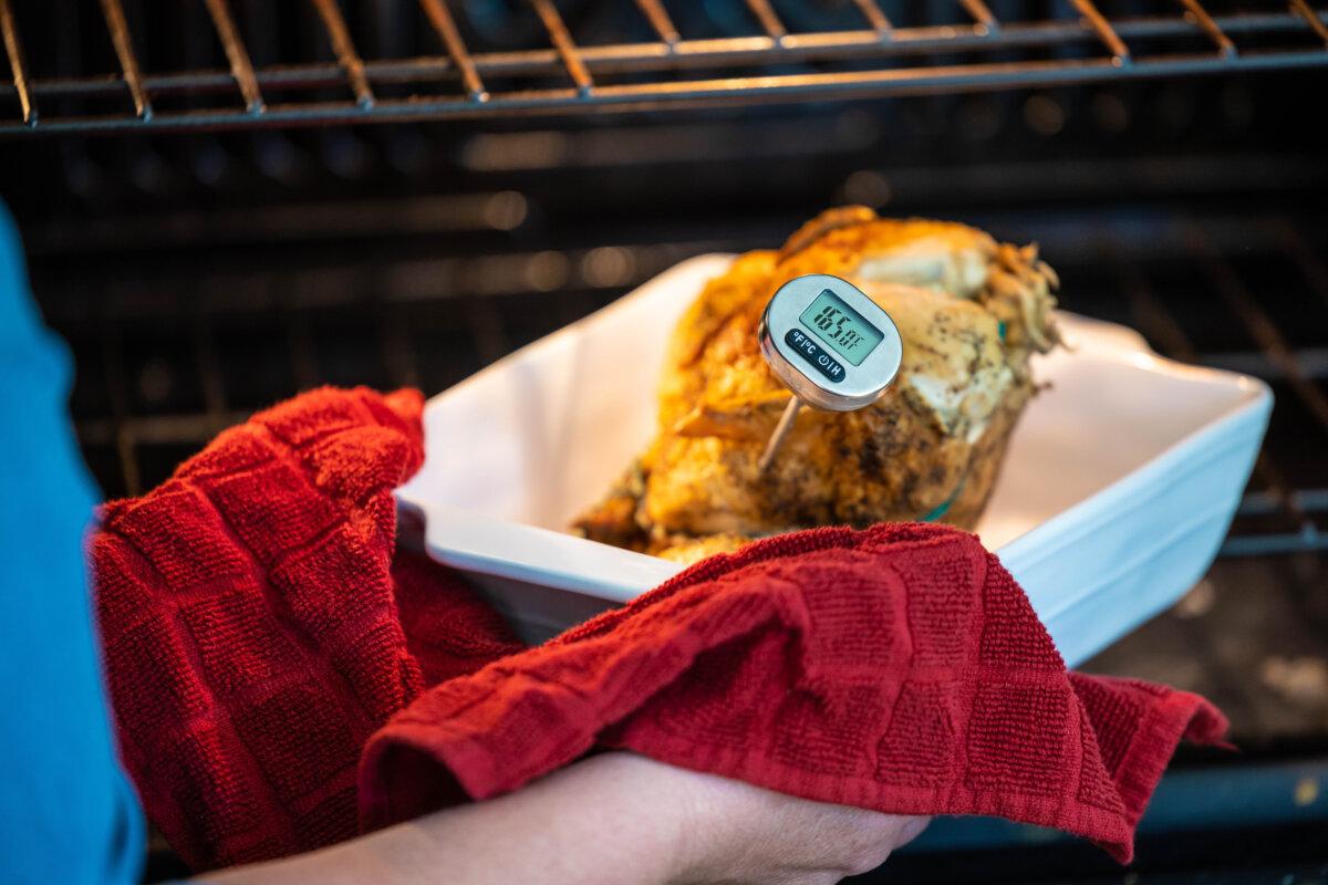Using a digital food thermometer to check the temperature of cooked meat. (LPETTET/Getty Images)