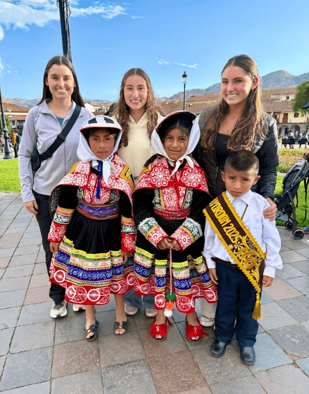 Cassie (L), Alexis (C), and Jessie Ross (R) with three local children in Peru, 2025. (Courtesy of the Ross family)