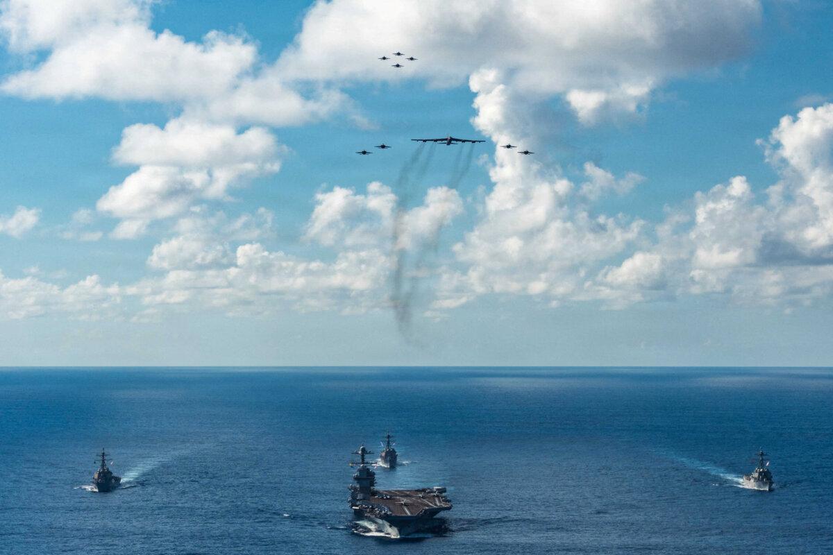 The U.S. Navy’s Gerald R. Ford Carrier Strike Group, including the flagship USS Gerald R. Ford, USS Winston S. Churchill, USS Mahan and USS Bainbridge, sail towards the Caribbean Sea under F/A-18E/F Super Hornets and a U.S. Air Force B-52 Stratofortress, in the Atlantic Ocean on Nov. 13, 2025. (U.S. Navy/Petty Officer 3rd Class Gladjimi Balisage/Handout via Reuters)