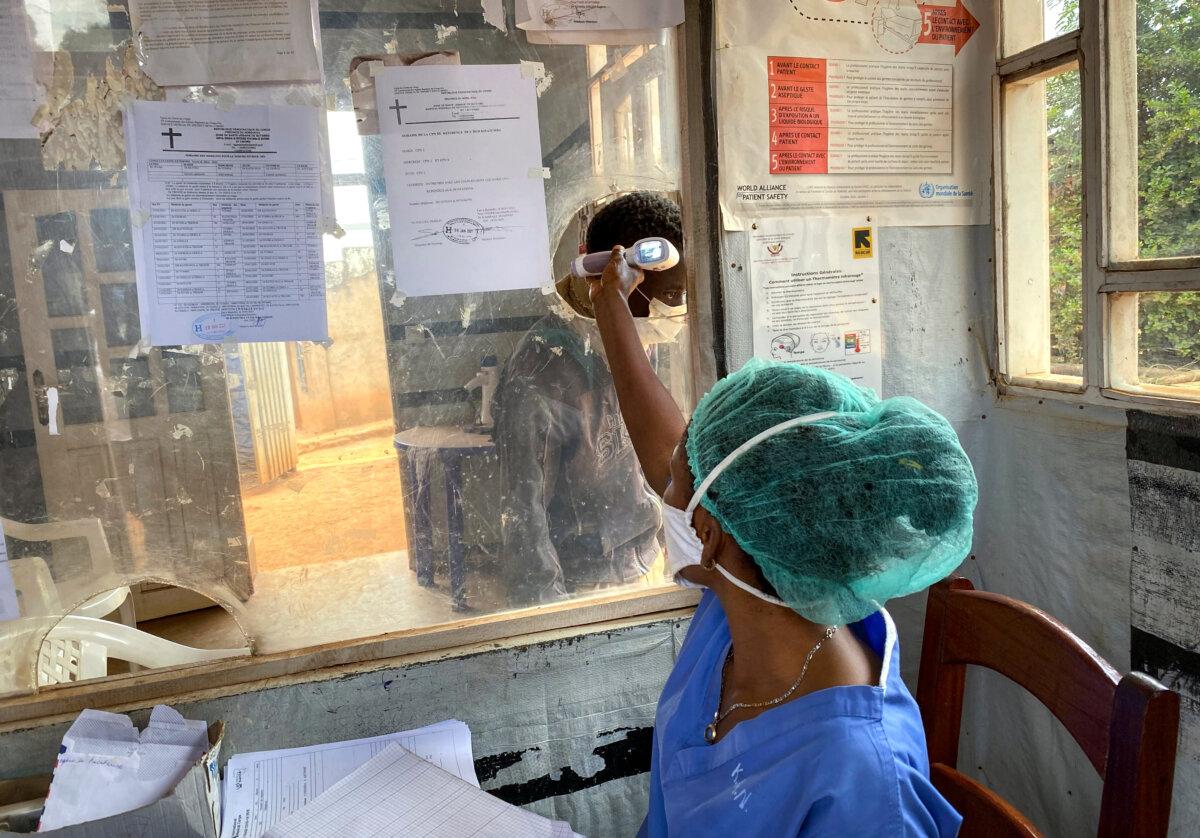 A medical worker checks a person's temperature at the Matanda Hospital in Butembo, where the first Ebola victim died in a previous outbreak of the virus in the North Kivu province of Congo, on Feb. 11, 2021. (Al-hadji Kudra Maliro/AP Photo)