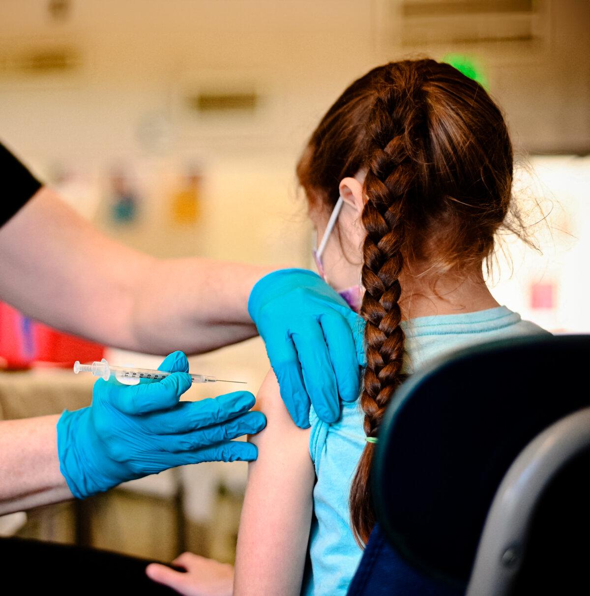 A nurse administers a pediatric dose of the COVID-19 vaccine to a girl at an L.A. Care Health Plan vaccination clinic at Los Angeles Mission College in the Sylmar neighborhood in Los Angeles, on Jan. 19, 2022. (Robyn Beck / AFP via Getty Images)