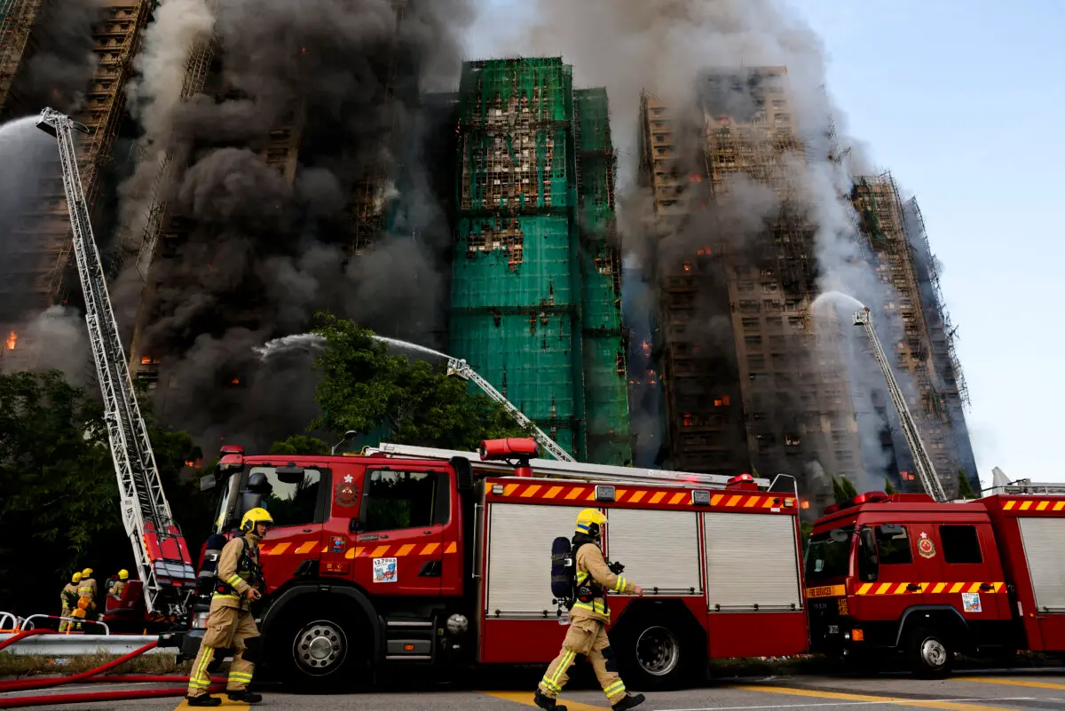 Firefighters work as efforts are underway to extinguish flames engulfing bamboo scaffolding across multiple buildings at the Wang Fuk Court housing estate in Tai Po, Hong Kong, on Nov. 26, 2025. (Tyrone Siu/Reuters)
