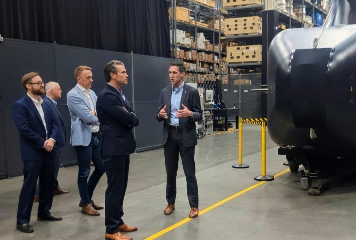 Andrew Nuss (R), head of growth and strategy for Anduril Industry's maritime division, speaks with Defense Secretary Pete Hegseth about the Dive-XL underwater autonomous vehicle program, during a tour of Anduril Industry's corporate campus in Costa Mesa, Calif., on Dec. 5, 2025. (Ryan Morgan/The Epoch Times)