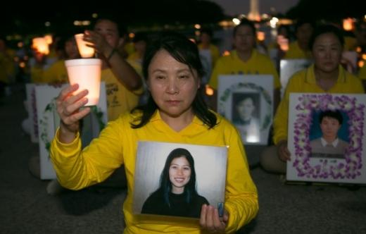 Gao Weiwei, holding a photo of her sister Gao Rongrong, attends a candelight vigil in Washington in July 2016 to commemorate the Falun Gong practitioners who lost their lives due to persecution by the Chinese Communist Party. (The Epoch Times)