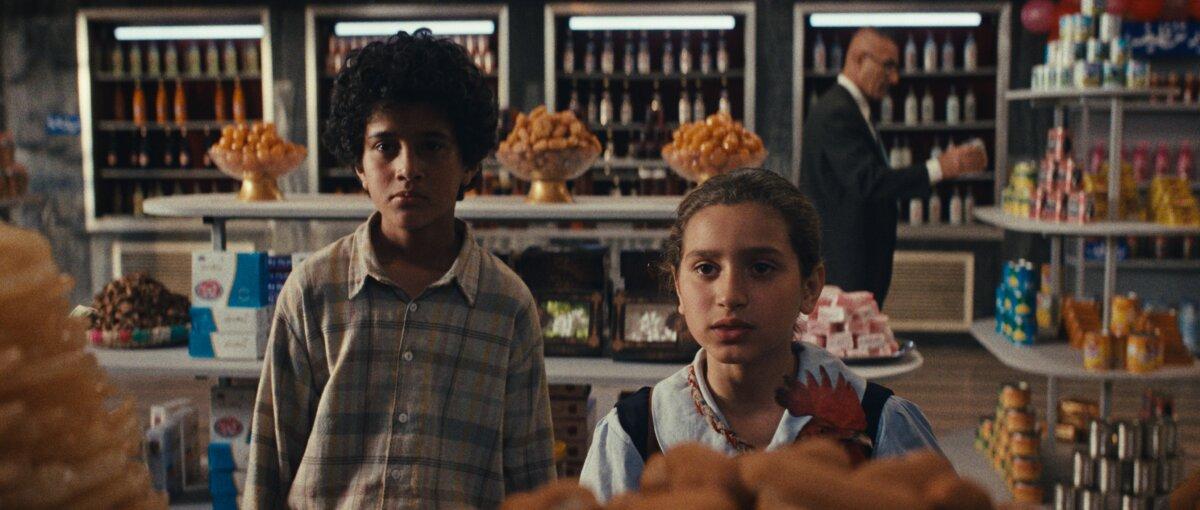Saeed (Sajad Mohamad Qasem) and Lamia (Baneen Ahmad Nayyef) look for cake ingredients in a shop, in “The President’s Cake.” (Sony Pictures Classics)