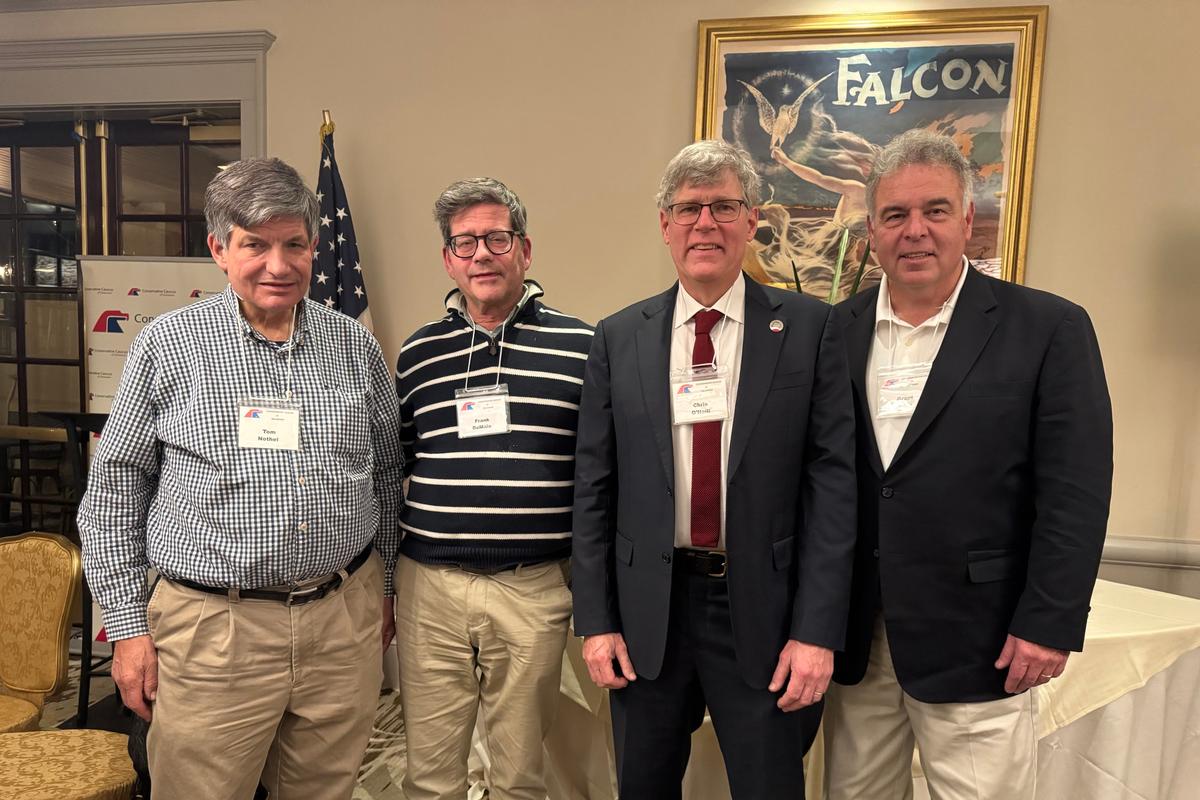 Chris O’Neill (2nd R) poses for a photo with high school friends at the “Welcome Home” party hosted by the Conservative Caucus of Delaware on Dec. 4, 2025. (Lily Sun/The Epoch Times)