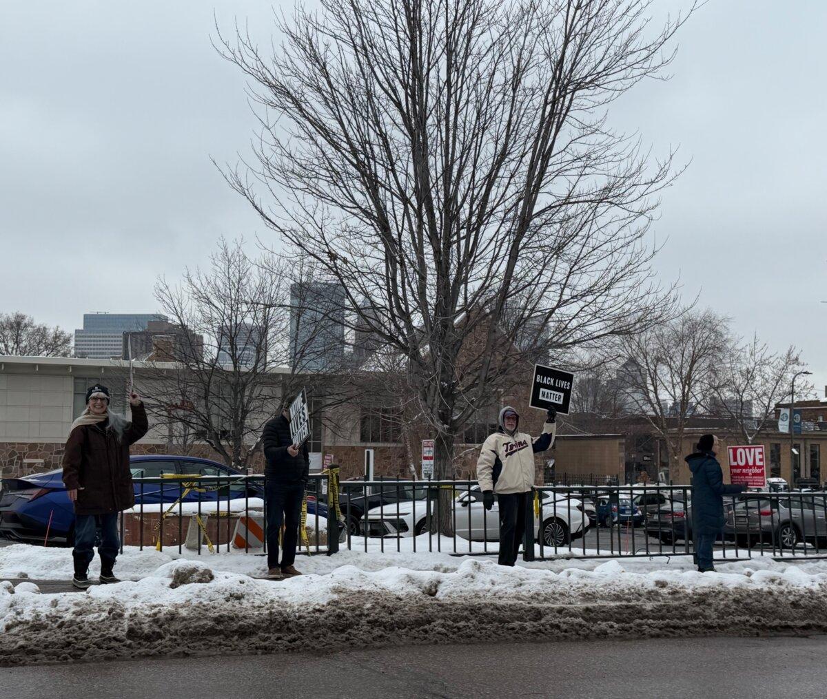Protesters hold signs such as "Black Lives Matter" and "Love Your Neighbor" in opposition to immigration-enforcement operations in Minneapolis, Minn., on Dec. 9, 2025. (Janice Hisle/The Epoch Times)