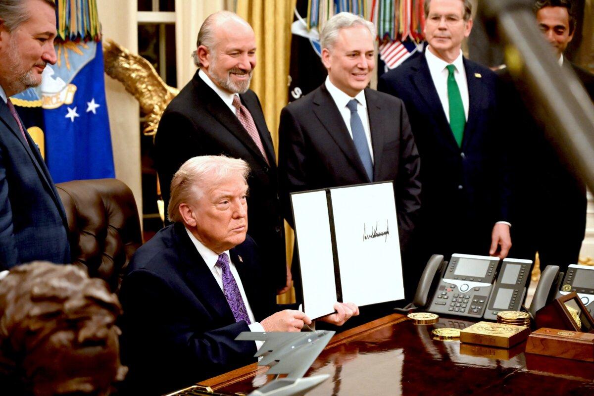 President Donald Trump holds up his signed AI initiative during a signing ceremony in the Oval Office of the White House on Dec. 11, 2025. (Alex Wroblewski/AFP via Getty Images)