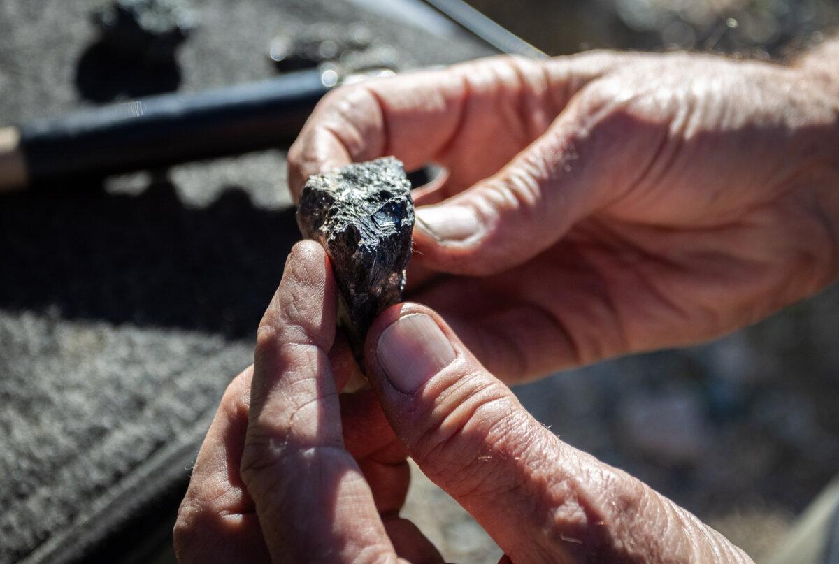 A prospector displays a sample of rare earth minerals in San Bernardino County, Calif., on Dec. 10, 2025. (John Fredricks/The Epoch Times)