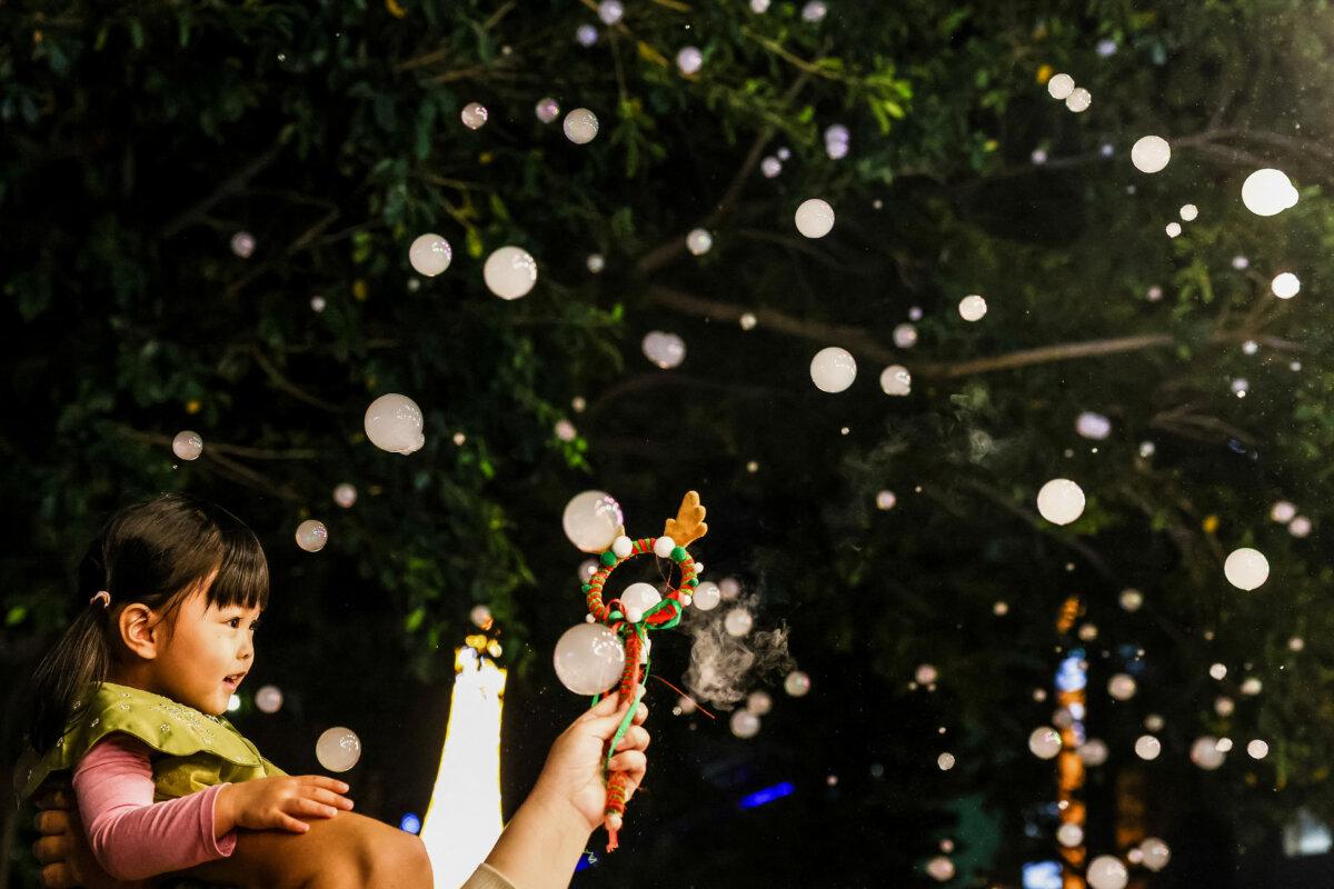 Taiwan Gets Dec. 25 Off for First Time in Over 2 Decades | USNN World News A child enjoys artificial snowfall at a street decorated with lights ahead of the Christmas festival in Pingtung on Dec. 22, 2025. (I-Hwa Cheng/AFP via Getty Images)