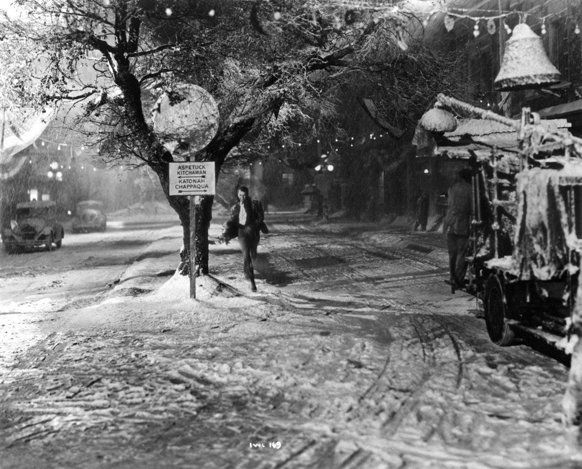 On-set photograph of Jimmy Stewart in "It's a Wonderful Life" (1946). The scene was not used in the movie and shows a street sign indicating nearby towns. (Public domain)