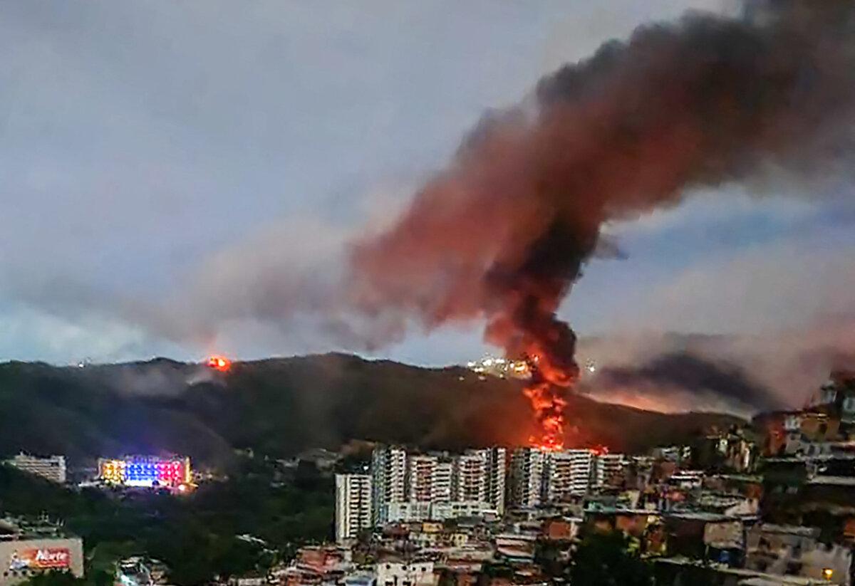 Fire at Fuerte Tiuna, Venezuela's largest military complex, is seen from a distance after a series of explosions in Caracas, on Jan. 3, 2026. (AFP via Getty Images)