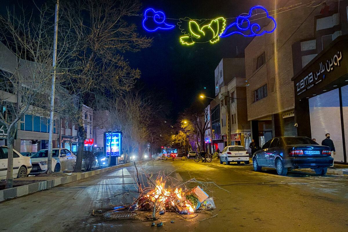 Burning debris lies in the middle of a street during demonstrations in Hamedan, Iran, on Jan. 1, 2026. (Mobina/Middle East Images/AFP via Getty Images)