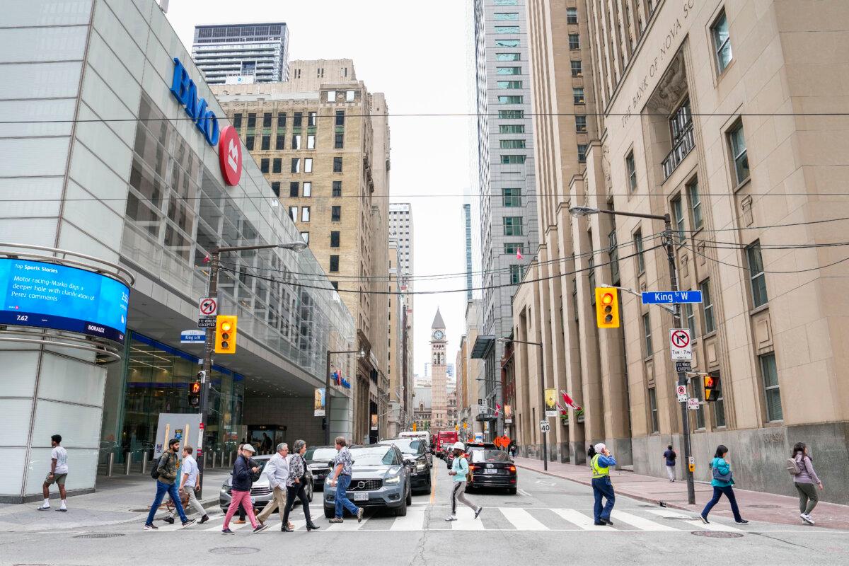 A general view of pedestrians crossing Bay St. in the financial district in Toronto, on Sept. 8, 2023. (The Canadian Press/Andrew Lahodynskyj)