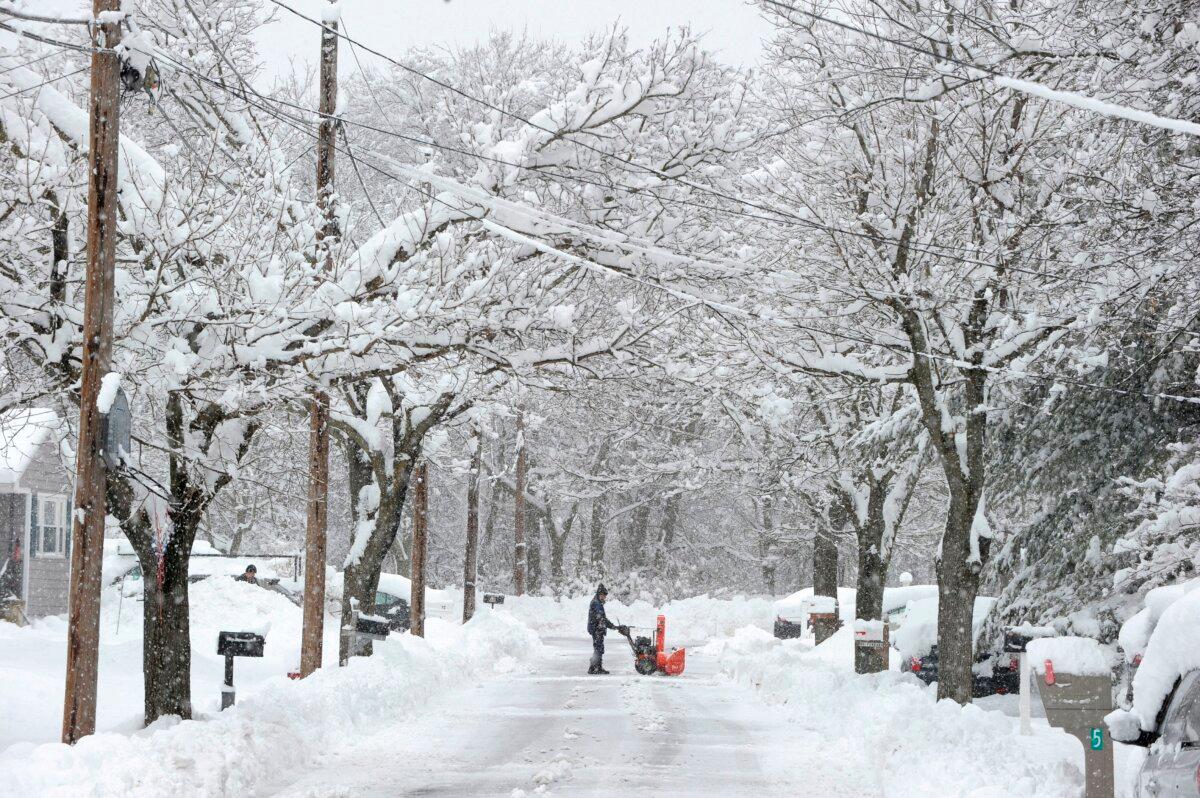 People uses shovels and snow blowers to clear their properties after a snowstorm dumped around 15 inches of snow around the Greater Boston area in Saugus, Mass., on March 4, 2019. (Joseph Prezioso/AFP via Getty Images)