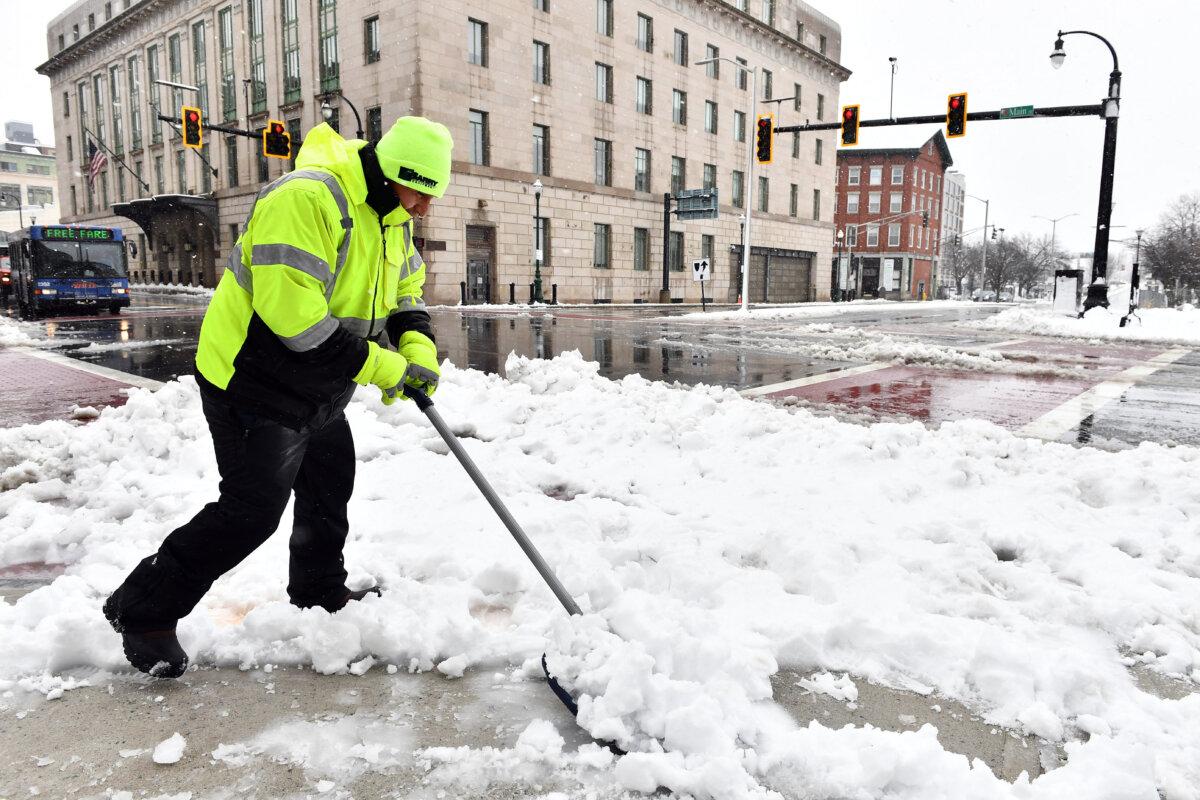 A person clears snow from the sidewalk in Worcester, Mass., on March 14, 2023. (Joseph Prezioso/AFP via Getty Images)