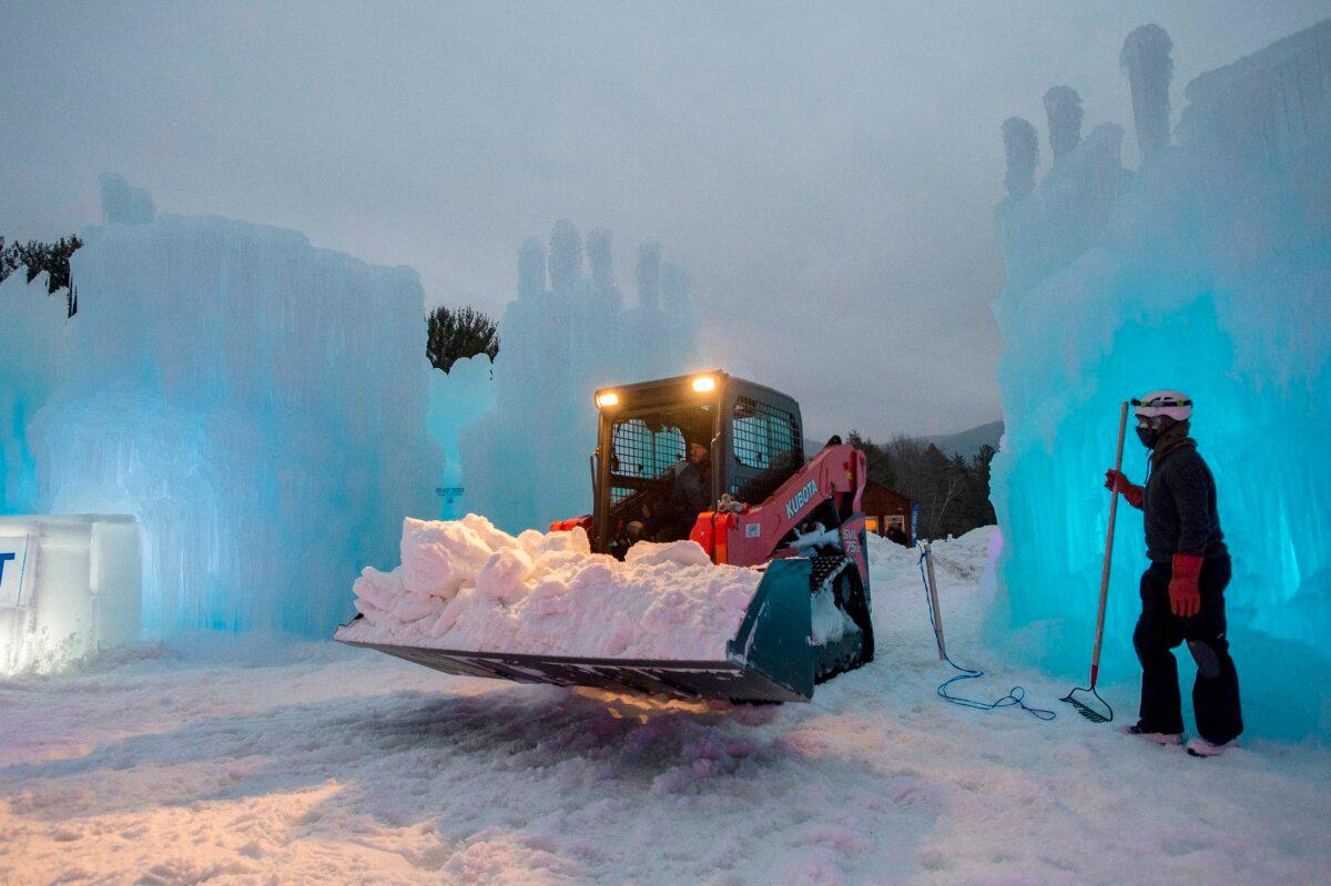 A truck carries in more snow to finalize one of the snow slides at Ice Castles in North Woodstock, N.H., on Jan. 14, 2021. (Joseph Prezioso/AFP via Getty Images)