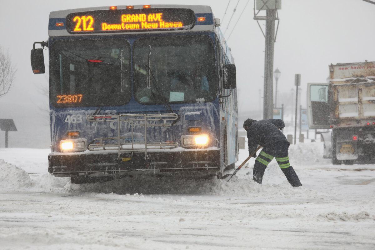 A city worker digs out a bus from the snow in New Haven, Conn., on Jan. 4, 2018. (John Moore/Getty Images)