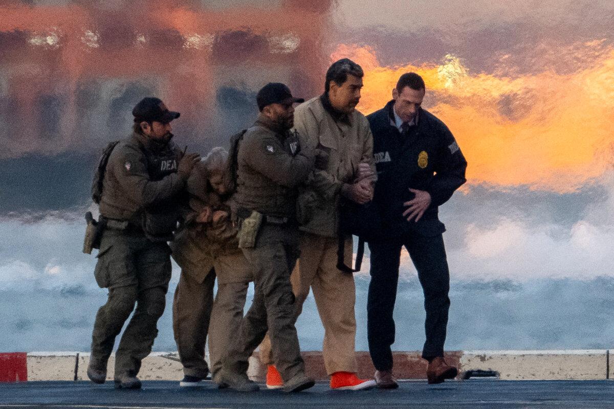 Tổng thống Venezuela Nicolas Maduro và vợ, bà Cilia Flores, được hộ tống tại một sân bay trực thăng ở thành phố New York vào ngày 5 tháng 1 năm 2026, khi họ đến tòa án Manhattan để trình diện lần đầu trước các cáo buộc liên bang của Mỹ, bao gồm khủng bố ma túy, âm mưu, buôn bán ma túy và rửa tiền. (Adam Gray/Reuters)