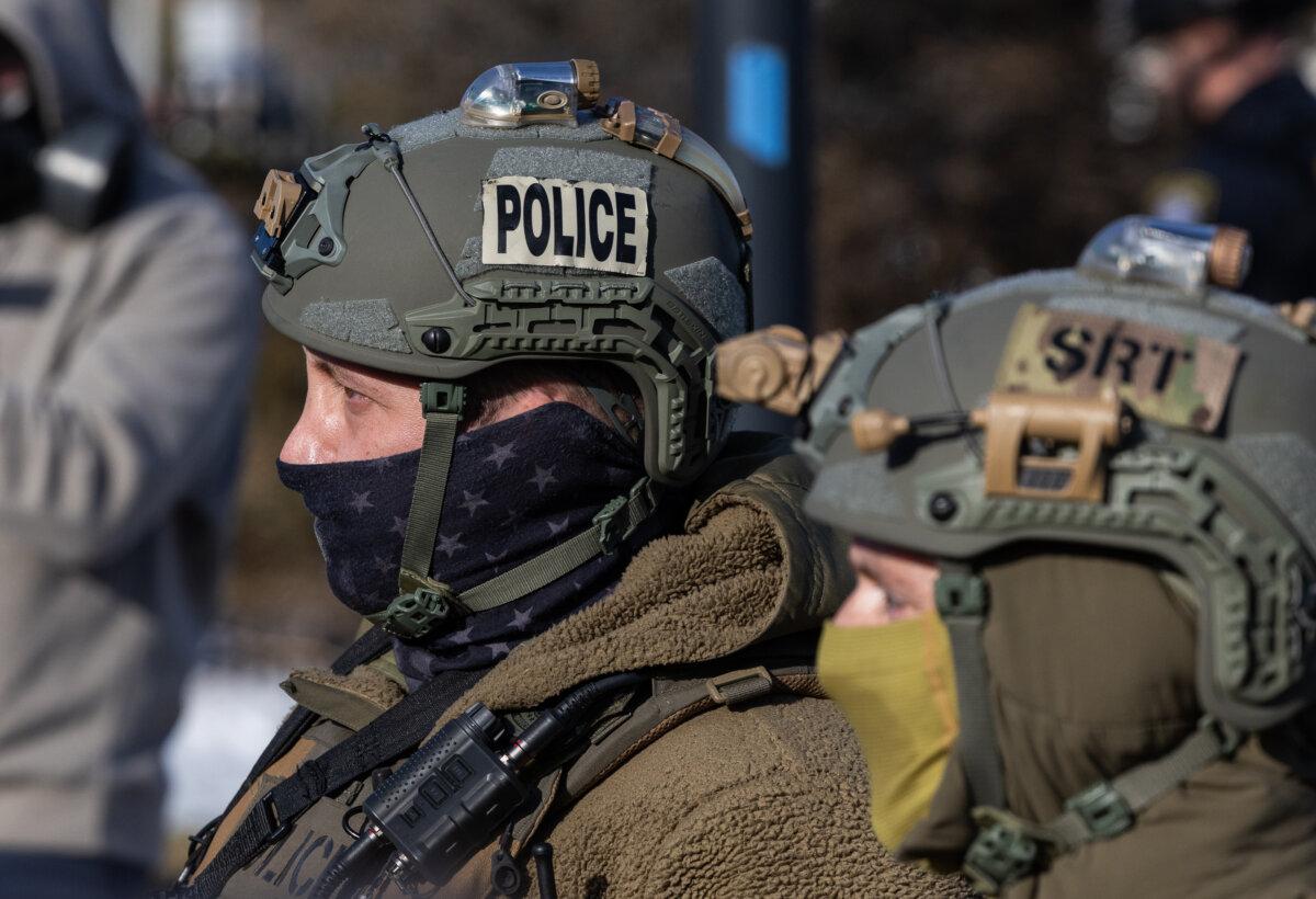 Protesters face off with federal officers in front of the Bishop Henry Whipple Federal Building in Minneapolis on Jan. 9, 2026. (John Fredricks/The Epoch Times)