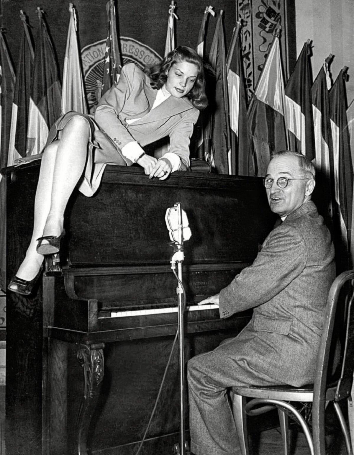 Lauren Bacall lounges on top of the piano while Vice President Harry S. Truman plays for servicemen at the National Press Club Canteen on Feb. 10, 1945 in Washington. (Public Domain)