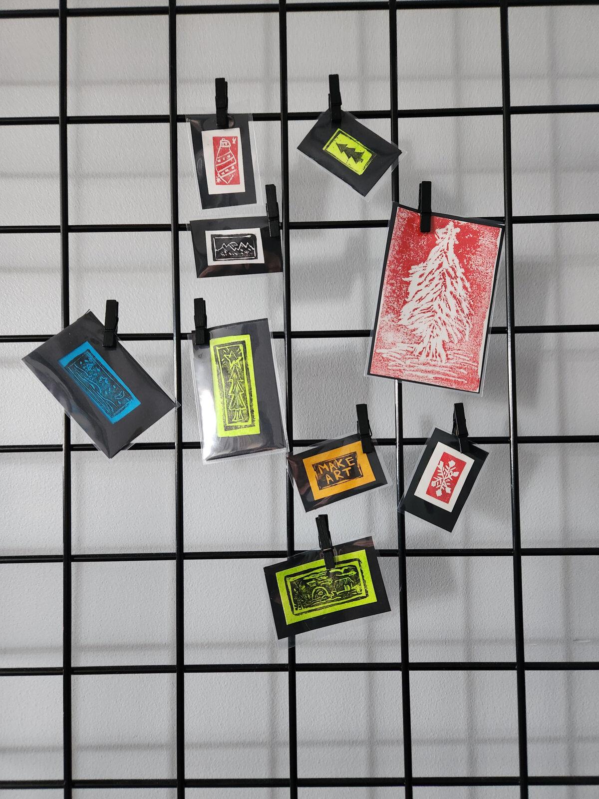Tiny art created while traveling is clipped to a gridwall panel for a minimalist, low-cost display. (Myscha Theriault/TNS)