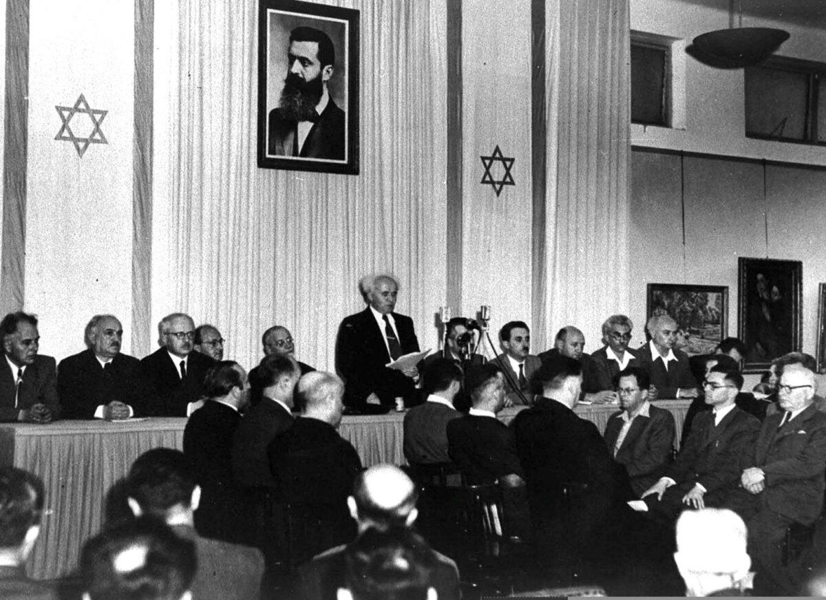 Israeli Prime Minister David Ben-Gurion, flanked by members of his provisional government, reads Israel’s Declaration of Independence in Tel Aviv on May 14, 1948. (GPO/AFP via Getty Images)