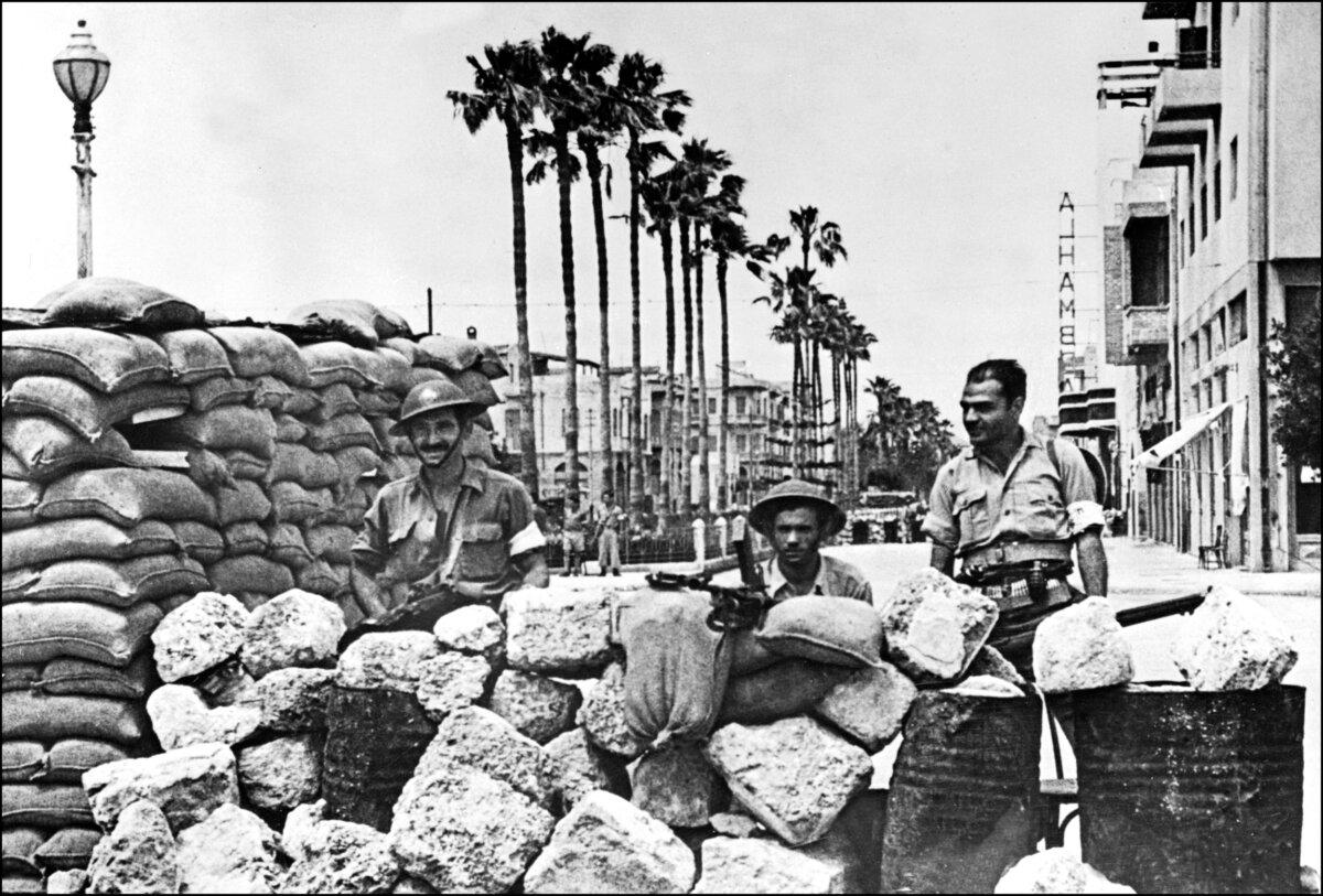 Members of the Haganah, the Jewish Agency’s self-defense force, stand guard behind a barricade in Jaffa streets during fighting with Arab forces on May 21, 1948. The Arab forces invaded Israel soon after the independence of the Jewish state was declared. (AFP via Getty Images)
